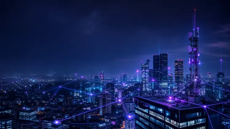 Vista aérea nocturna de una gran ciudad con una malla luminosa que representa la red móvil